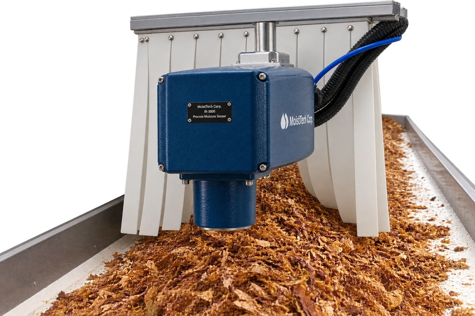 Sensor MoistTech 828 midiendo sin contacto sobre tabaco cortado en un canal transportador, con la óptica apuntando al producto y faldones flexibles a ambos lados